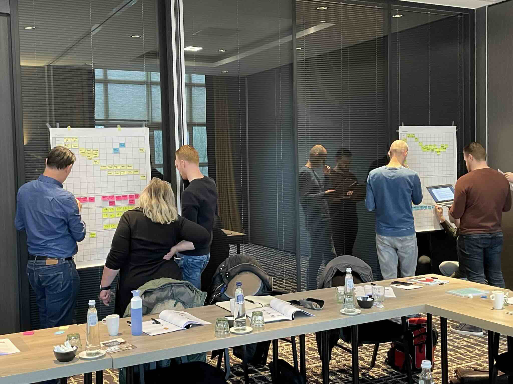 Deelnemers bespreken oorzaken en verbeterpunten bij een visgraatdiagram op een whiteboard.