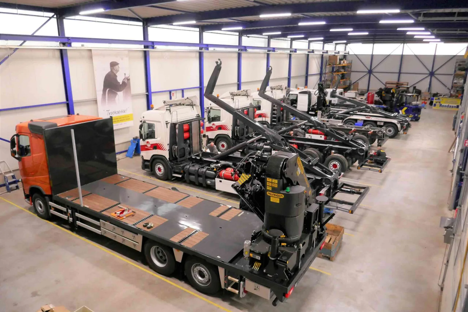 Meerdere vrachtwagenchassis staan in een productiehal voor carrosseriebouw.